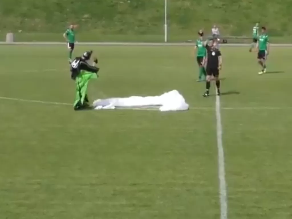 Seorang pria mendarat di tengah pertandingan sepak bola. (Photo/Twitter/@wmzpn)
