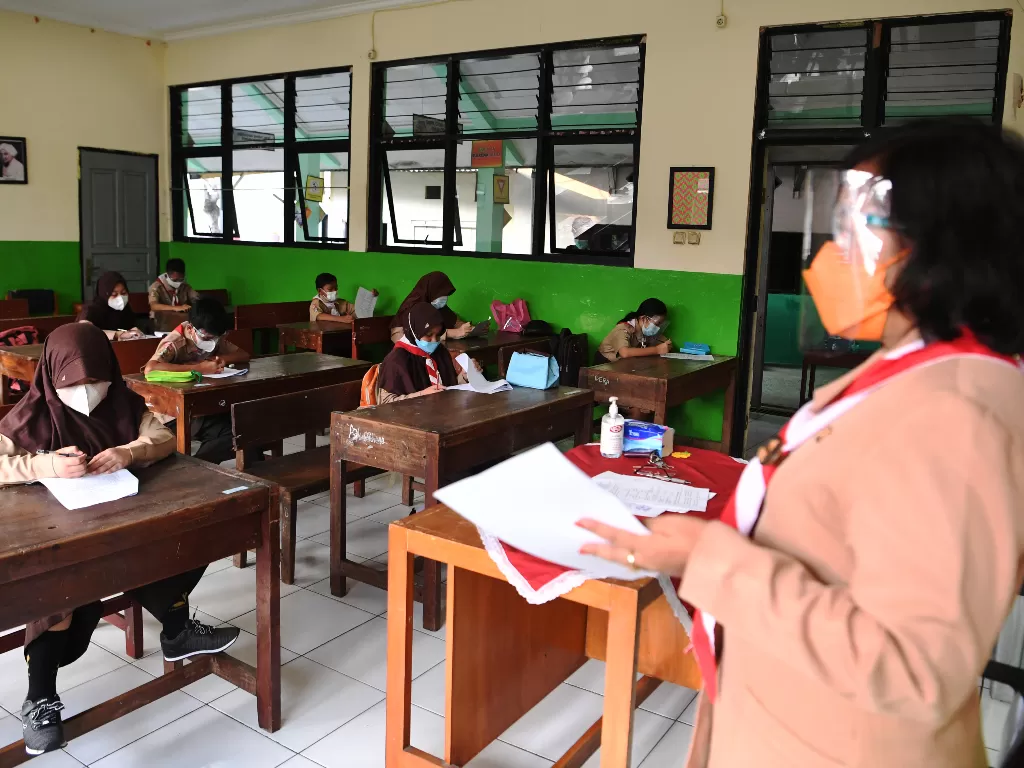 Sejumlah murid mengerjakan soal Penilaian Akhir Tahun (PAT) saat menjalani uji coba pembelajaran tatap muka (PTM) tahap 2 di SDN Kebayoran Lama Selatan 17 Pagi, Jakarta, Rabu (9/6/2021). (ANTARA/Hafidz Mubarak)