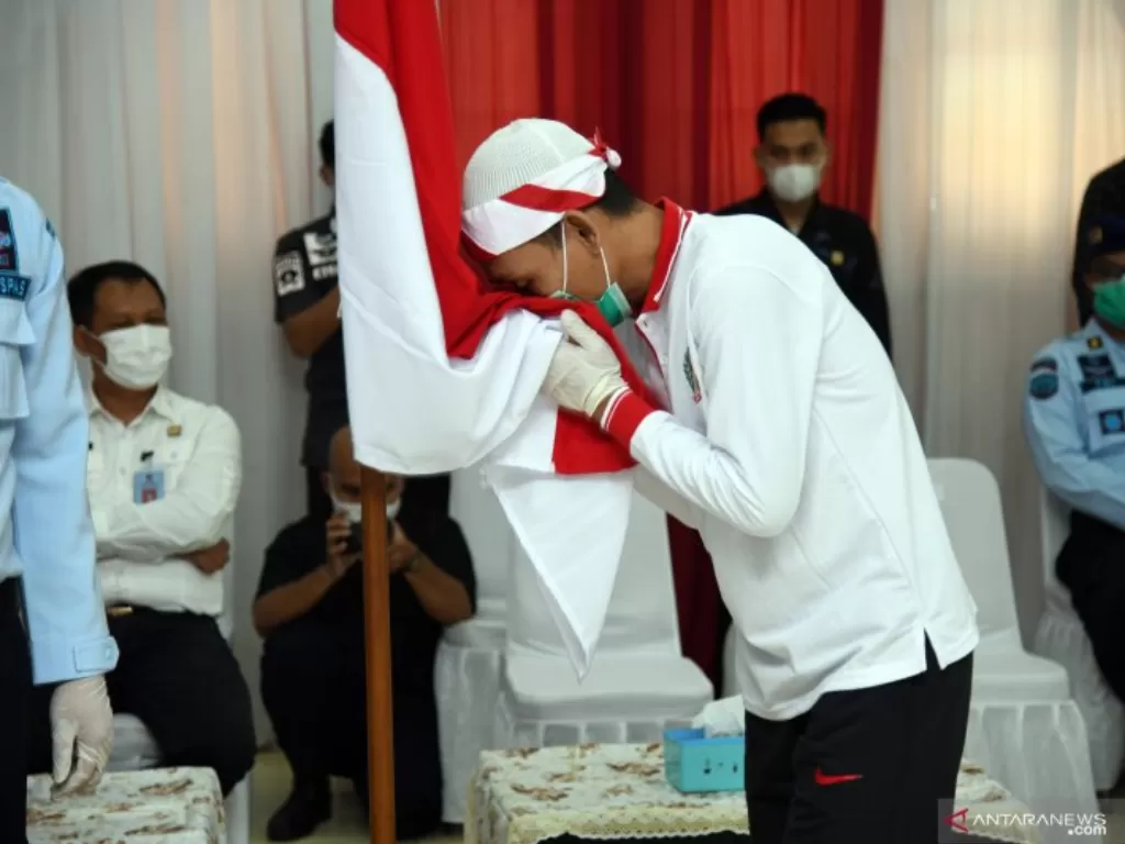 Dokumentasi narapidana teorisme mencium bendera Merah Putih usai mengucap ikrar setia kepada NKRI. (Foto: Humas Kementerian Hukum dan Hak Asasi Manusia)