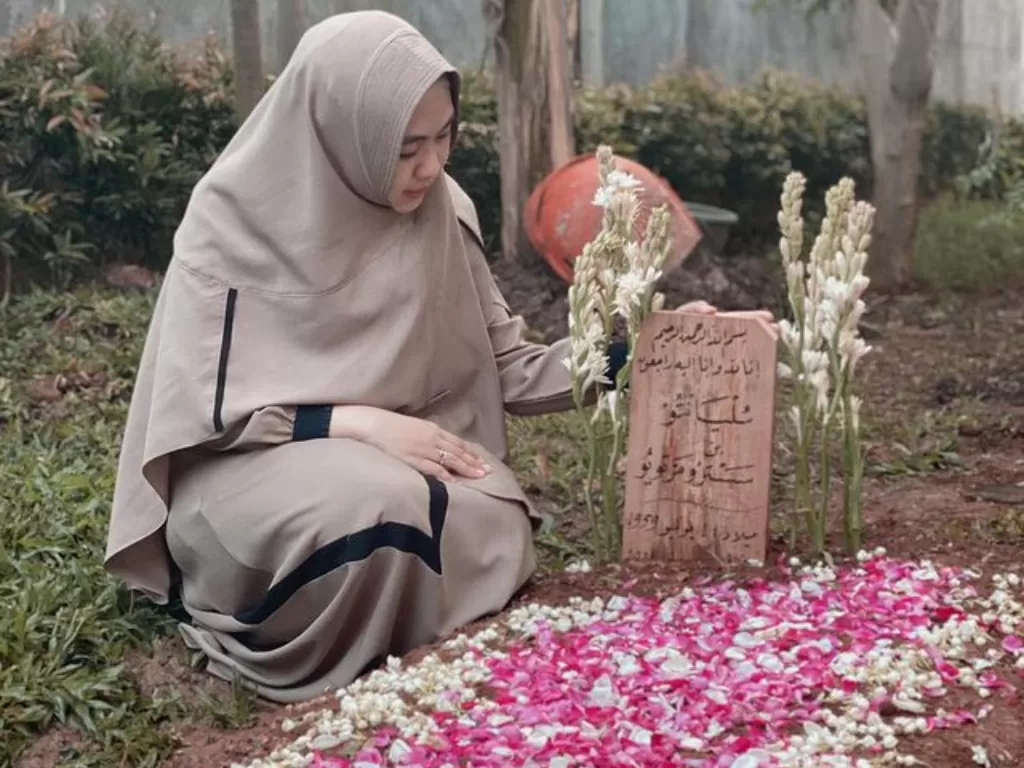 Oki Setiana Dewi di makam ayahnya. (Instagram/@okisetianadewi)