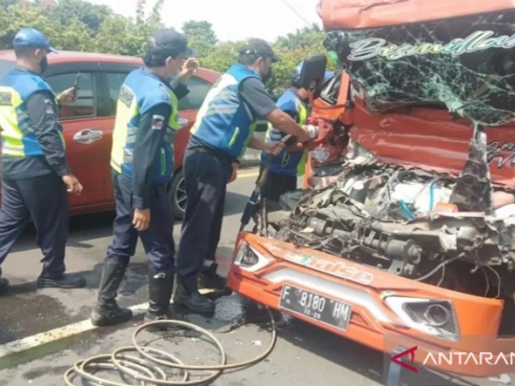  Petugas mengevakuasi pengemudi dan kenek truk tangki yang mengalami kecelakaan di Tol Rawamangun arah Tanjung Priok, Jakarta, Sabtu (12/6/2021). (photo/ANTARA/Twitter@TMCPoldaMetroJaya)
