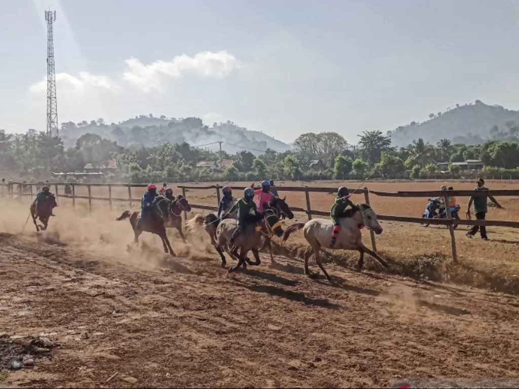  Para joki cilik dengan kuda pacuannya melaju kencang dalam sesi latihan di arena pacuan kuda Desa Panda, Bima, NTB, Minggu (13/6/2021). (ANTARA/Dhimas B.P.) 