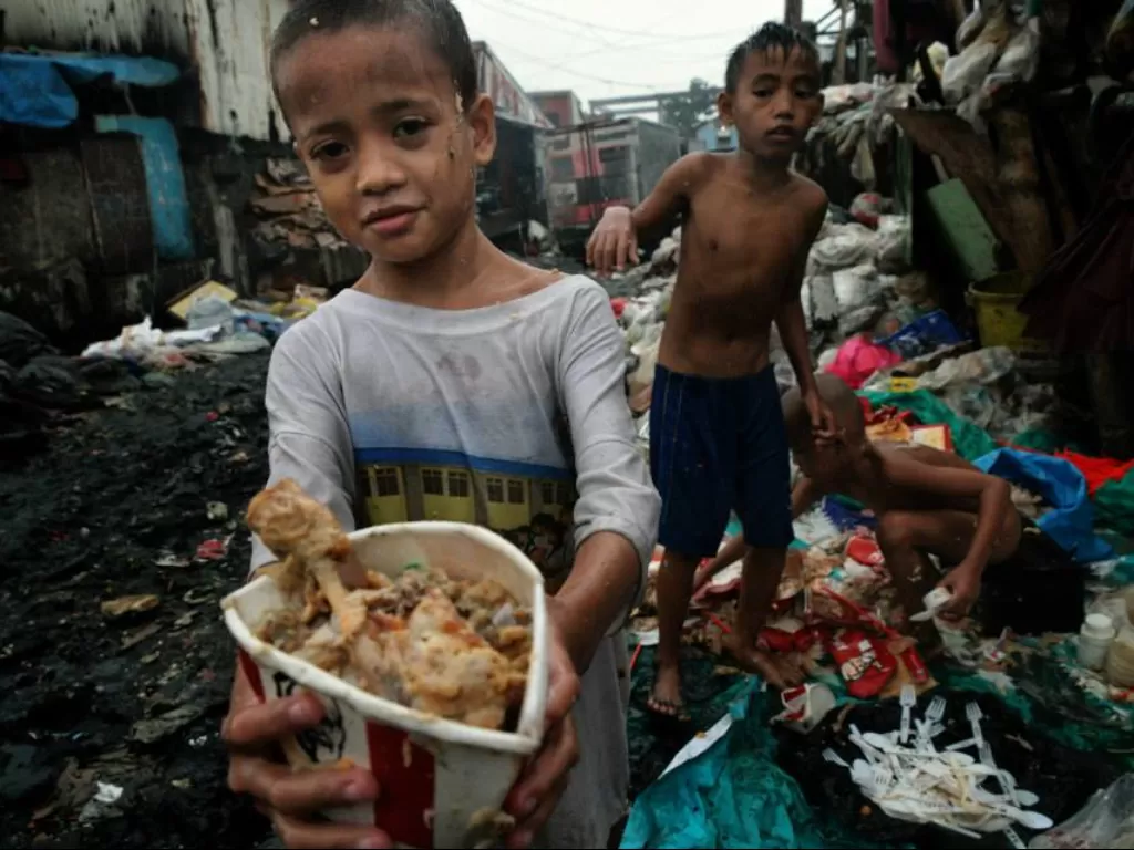 Anak-anak dari keluarga miskin di Filipina makan sisa makanan di tempat sampah. (Facebook/Empowering Lives Asia)