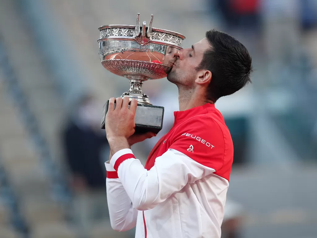 Novak Djokovic dari Serbia merayakan dengan trofi (REUTERS/Benoit Tessier)