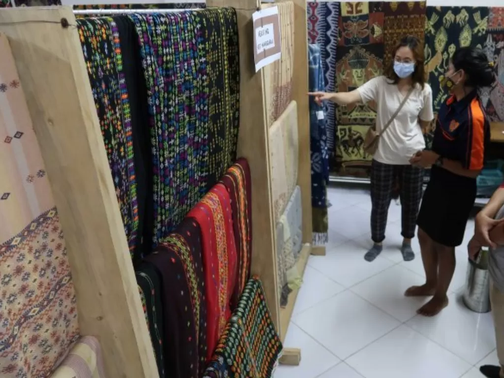 Pembeli memilih kain tenun di salah satu gerai oleh-oleh di Labuan Bajo, Manggarai Barat, Nusa Tenggara Timur, Minggu (13/6/2021). (ANTARA/Sugiharto Purnama) 