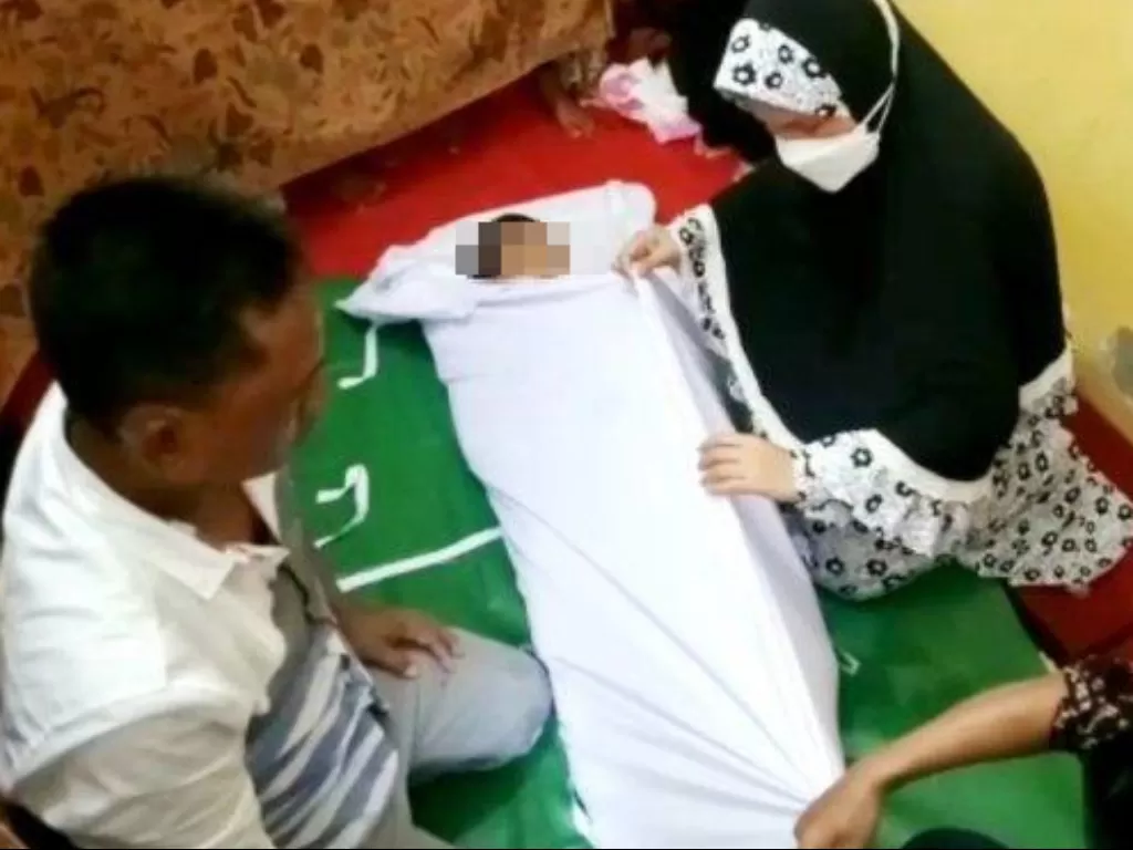 Orang tua Muhammad Raza Aulia (10 tahun) menangisi kematian anaknya usai digigit anjing rabies di Medan. (ist)