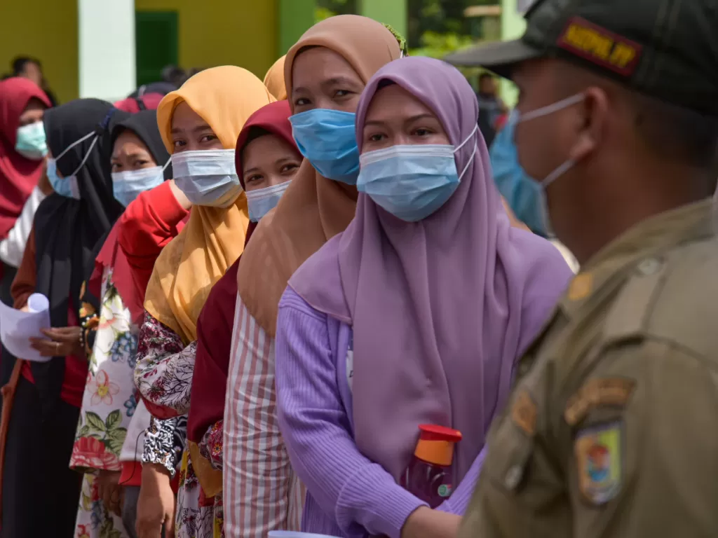 Sejumlah warga antre untuk mendapatkan vaksin COVID-19 di SMK Negeri 01 Perbaungan, Serdang Bedagai, Sumatera Utara, Rabu (16/6/2021). (ANTARA/Fransisco Carolio)