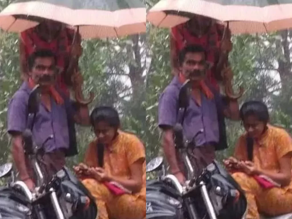 Perjuangan ayah yang melindungi anaknya dari hujan. (Photo/Twitter/@mvraoforindia)