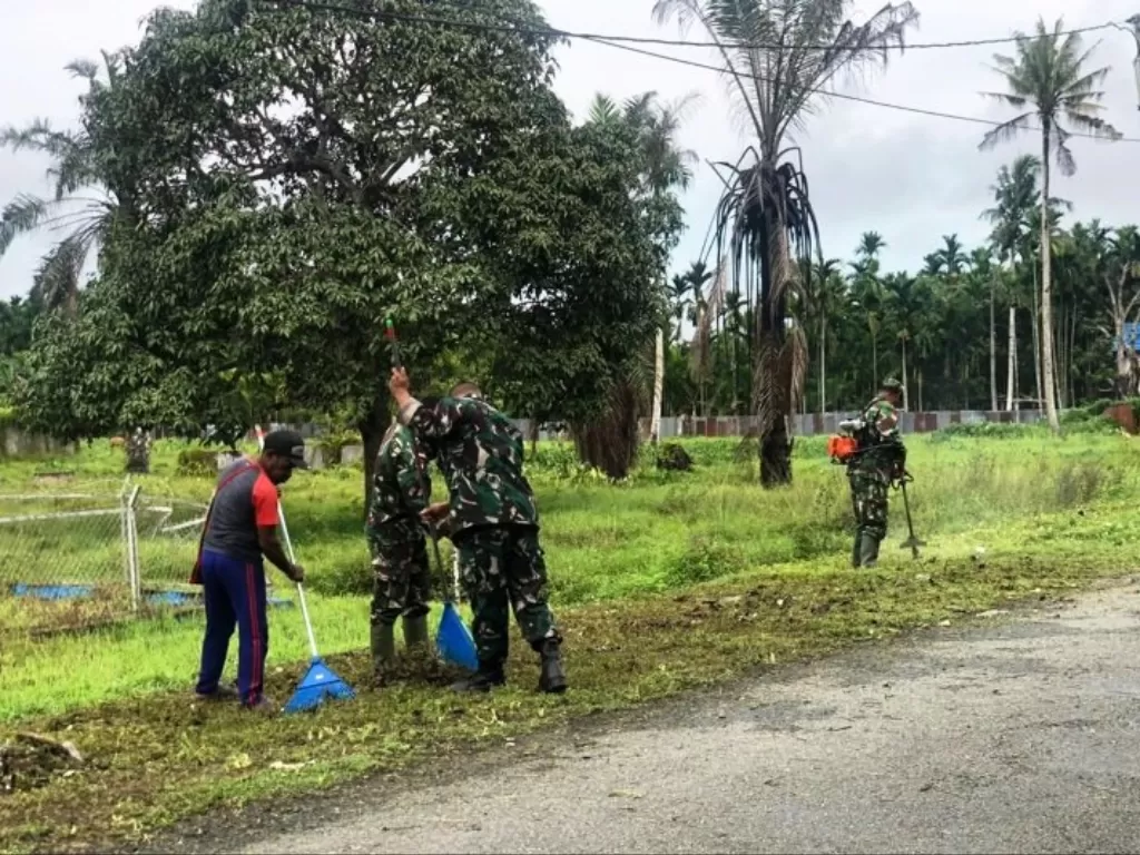  Warga kampung Wonoredjo di perbatasan RI-PNG bersama personel TNI membersihkan jalan dalam upaya menanamkan kesadaran menjaga lingkungan untuk tetap sehat dan bersih. (ANTARA/HO-Pendam XVII/Cenderawasih) 