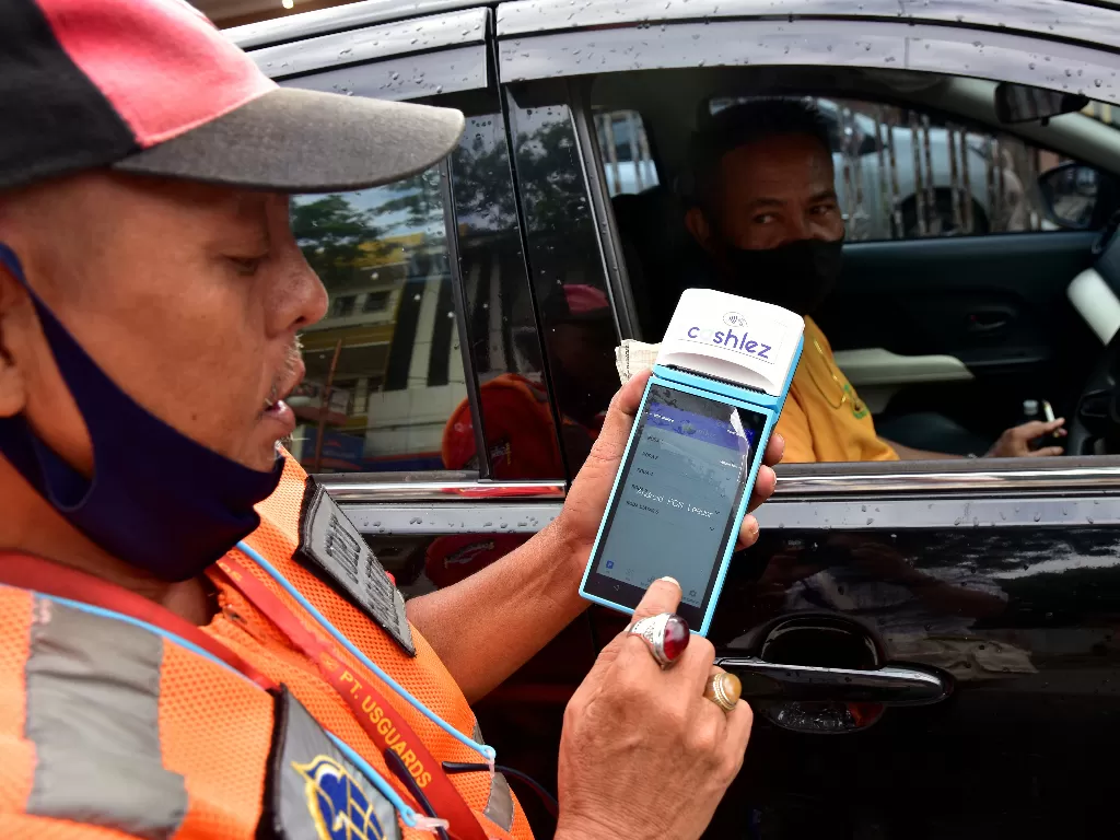 Seorang juru parkir menghitung tarif parkir dengan alat digital. (Foto: ANTARA/FB Anggoro)