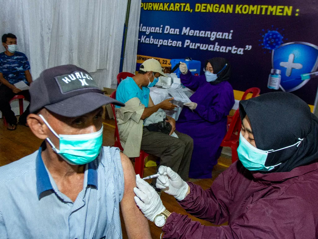Petugas kesehatan menyuntikkan vaksin COVID-19 saat vaksinasi massal di Gelanggang Olahraga (GOR) Purnawarman, Purwakarta, Jawa Barat, Rabu(23/6/2021). (ANTARA/M Ibnu Chazar)
