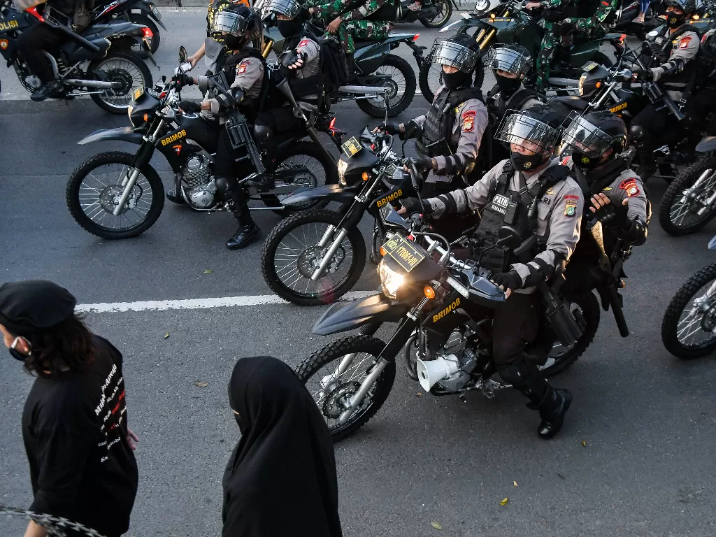 Sejumlah petugas kepolisian membubarkan massa pendukung Muhammad Rizieq Shihab usai sidang di Jalan Raya Penggilingan, Jakarta Timur. (ANTARA FOTO/ Fakhri Hermansyah).
