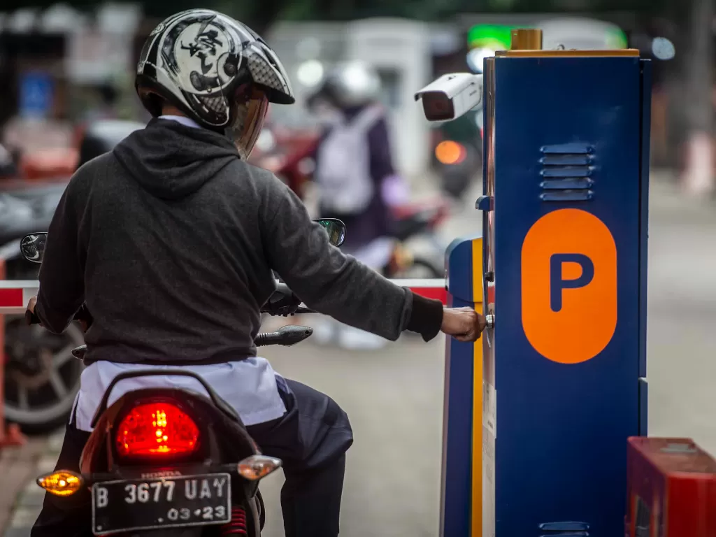 Pengendara sepeda motor mengambil karcis parkir di lapangan IRTI Monas, Jakarta Pusat, Jakarta, Rabu (23/6/2021). (photo/ANTARA FOTO/Aprillio Akbar/ilustrasi)