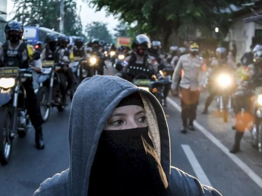 Sejumlah petugas kepolisian membubarkan massa pendukung Muhammad Rizieq Shihab usai sidang di Jalan Raya Penggilingan, Jakarta Timur. (ANTARA FOTO/Fakhri Hermansyah)