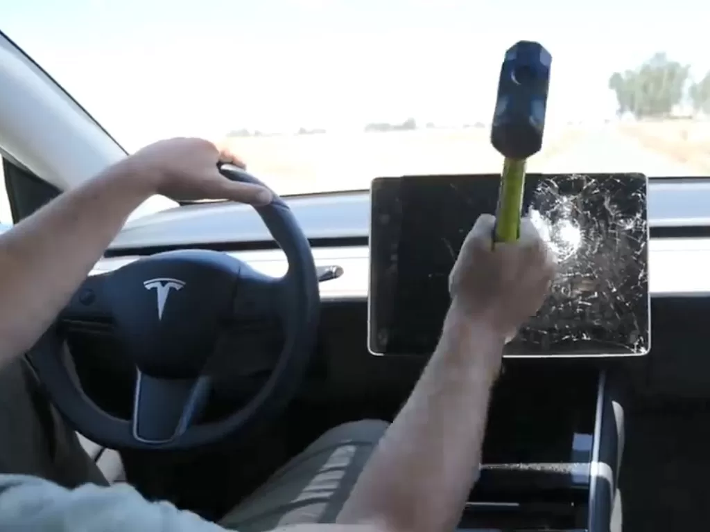 YouTuber TechRax saat menghancurkan layar di mobil Tesla dengan palu (photo/YouTube/TechRax)