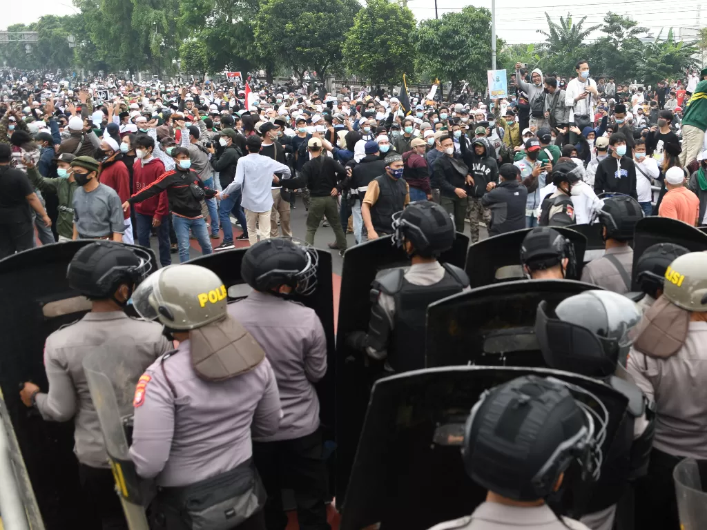 Polisi memblokade massa pendukung Rizieq Shihab di kawasan I Gusti Ngurah Rai saat akan menuju Pengadilan Negeri (PN) Jakarta Timur, Kamis (24/6/2021). (Foto: ANTARA/M Risyal Hidayat)