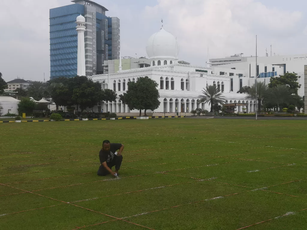 Pekerja membuat garis saf shalat Idul Fitri di Masjid Al Azhar, Jakarta. (Foto: ANTARA/Akbar Nugroho Gumay)