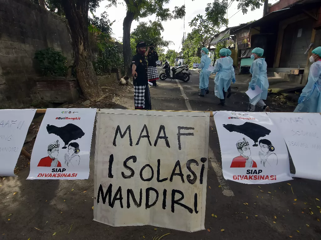 Petugas kesehatan memasuki area isolasi mandiri saat melakukan pendataan bagi warga yang terpapar Covid-19 di Banjar Terunasari, Desa Dauh Puri Kaja, Denpasar, Bali, Kamis (1/7/2021). (ANTARA FOTO/Nyoman Hendra Wibowo)