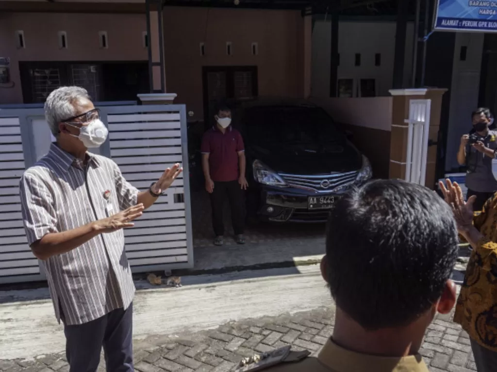 Gubernur Jawa Tengah Ganjar Pranowo (kiri) menyapa warga orang tanpa gejala (OTG) COVID-19 dengan jarak jauh di Kabupaten Batang, Jawa Tengah, Selasa (29/6/2021). (ANTARA FOTO/Harviyan Perdana Putra)
