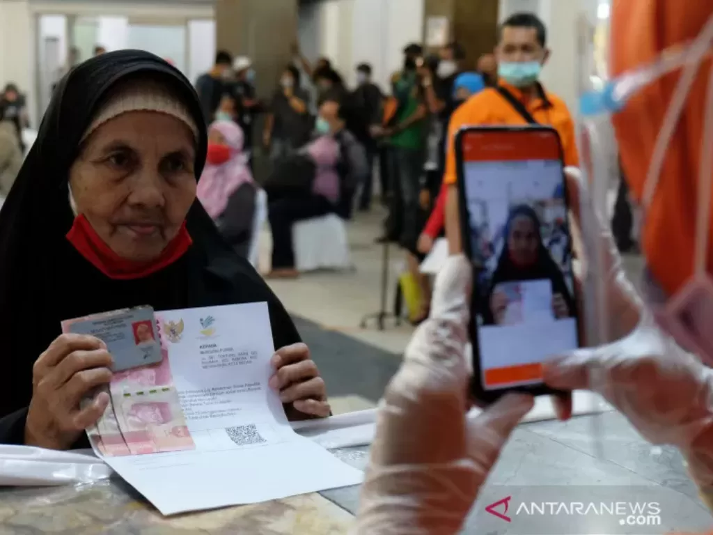 Ilustrasi - Petugas PT Pos Indonesia memotret wajah warga penerima Bantuan Sosial Tunai (BST) tahap VIII untuk kelengkapan administrasi pada proses penyaluran BST di Medan, Sumatera Utara, Jumat (13/11/2020). (photo/ANTARA FOTO/Irsan Mulyadi/ilustrasi)