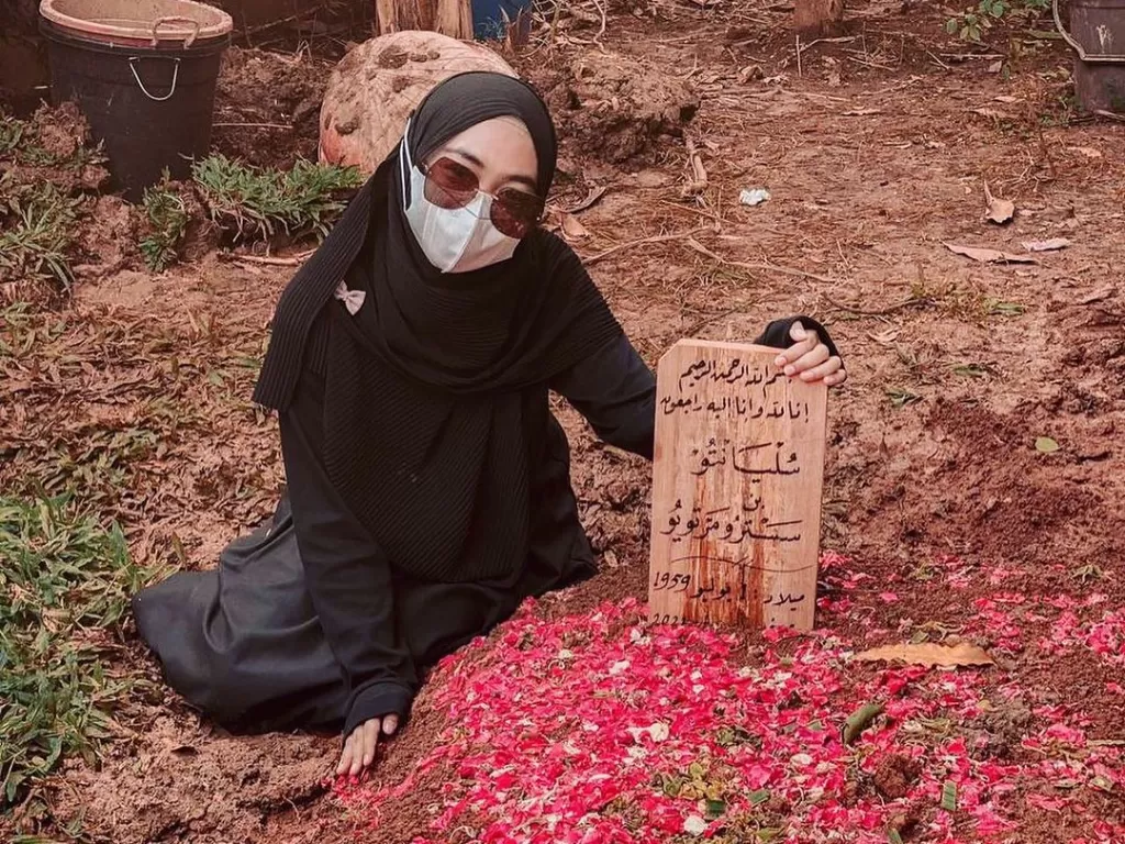Ria Ricis saat berpose di makam usai ayahnya dimakamkan. (Instagram/Ria Ricis)