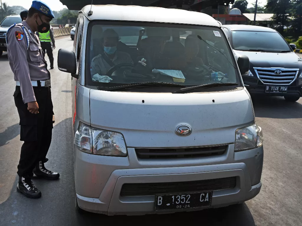 Anggota Polri memeriksa kelangkapan surat pengemudi kendaraan (ANTARA FOTO/Asep Fathulrahman)