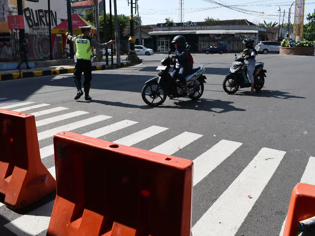 Polisi mengarahkan pengendara untuk berbalik arah di pos penyekatan Kota Madiun, Jawa Timur, Minggu (4/7/2021). Penyekatan di sejumlah akses menuju Kota Madiun dilakukan dalam rangka penerapan Pemberlakuan Pembatasan Kegiatan Masyarakat (PPKM) Darurat mul