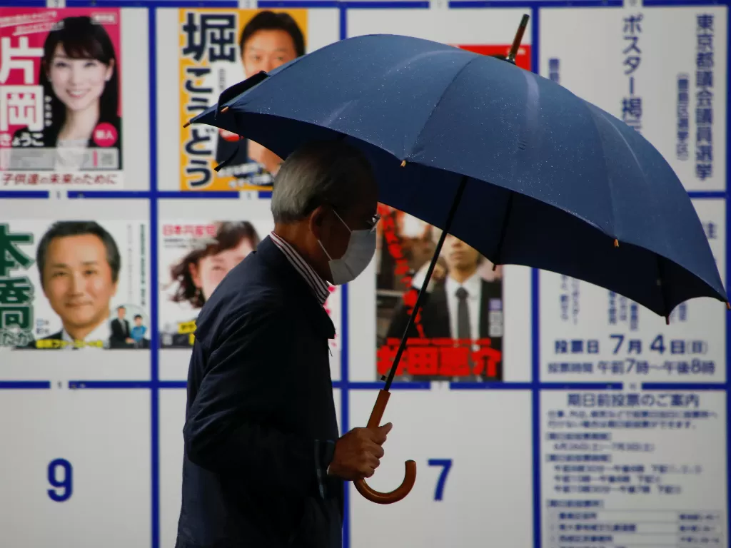 Seorang pejalan kaki menggunakan masker di Jepang. (REUTERS/Issei Kato)