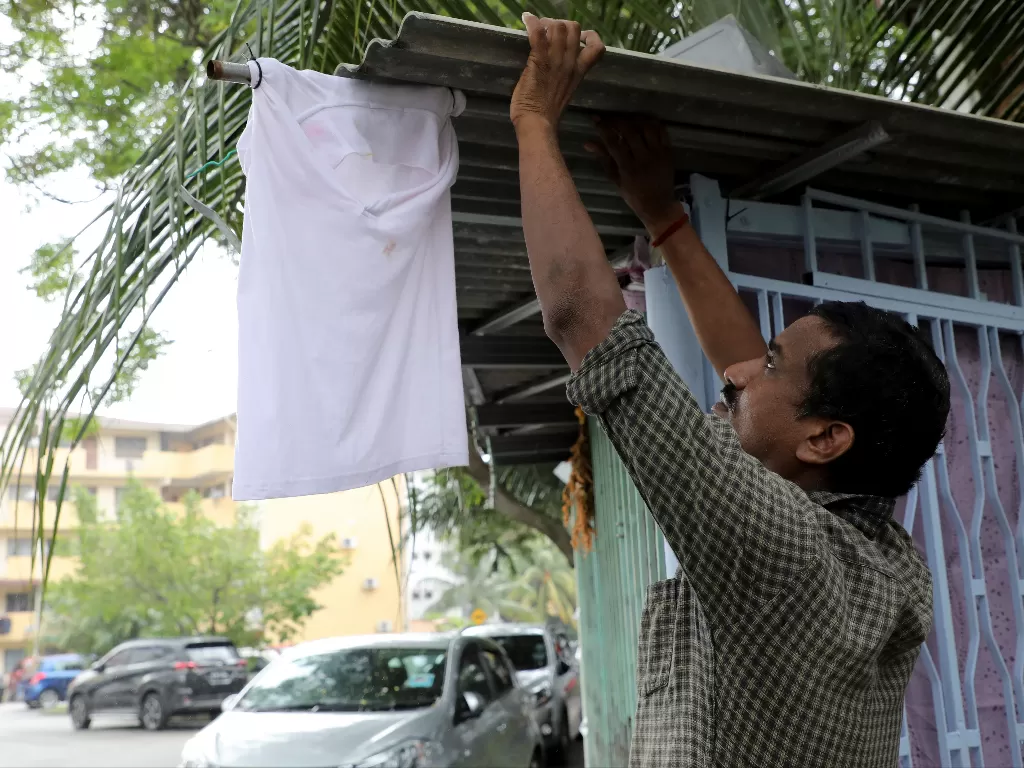 Warga Malaysia mengibarkan bendera putih di depan rumah. (Photo/Reuters)