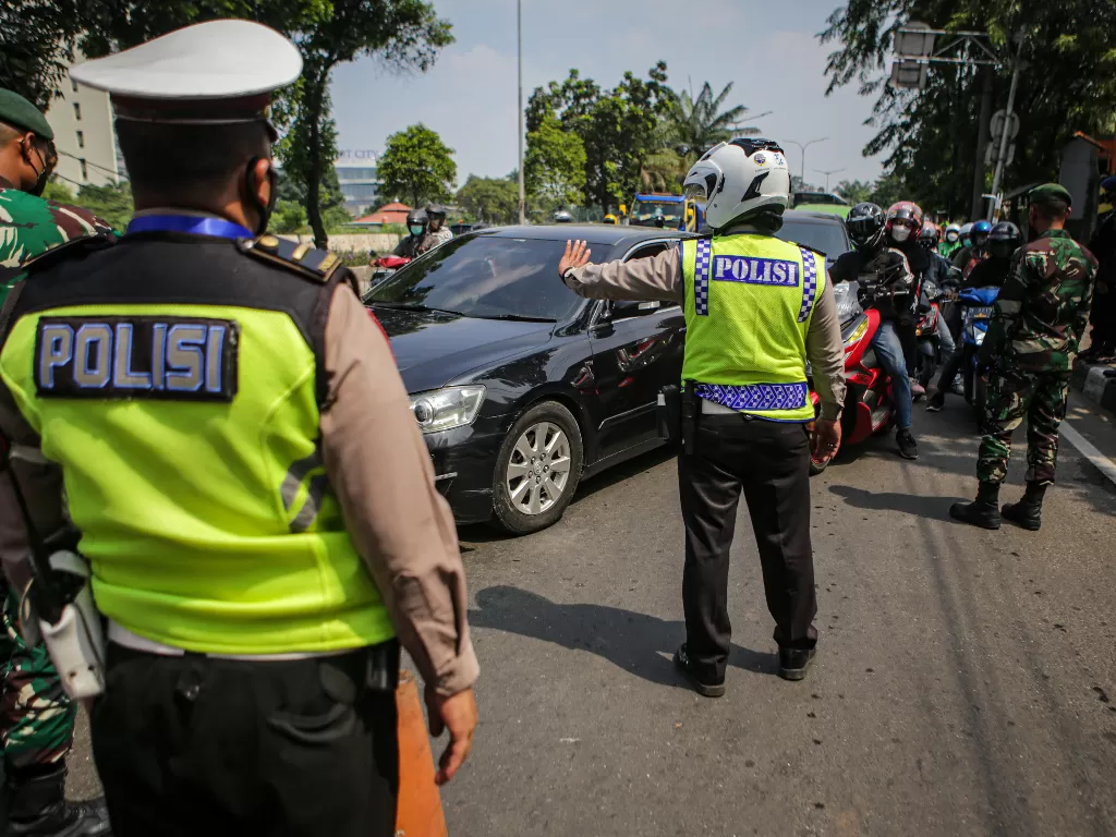 Petugas gabungan dari TNI dan Polri memutarbalik kendaraan saat PPKM darurat 2021. (ANTARA FOTO/Fauzan/wsj.)