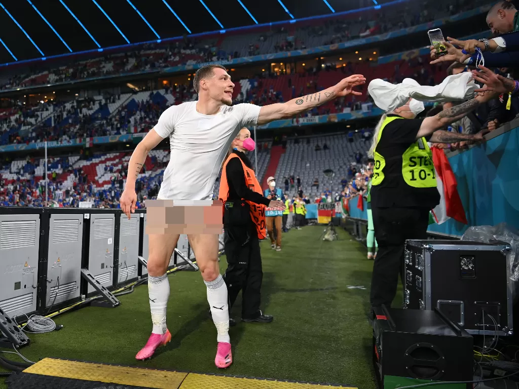 Penyerang Italia Andrea Belotti melemparkan celana pendeknya ke tribun penonton rayakan kemenangan atas Belgia di EURO 2020. (photo/REUTERS/MATTHIAS HANGST)