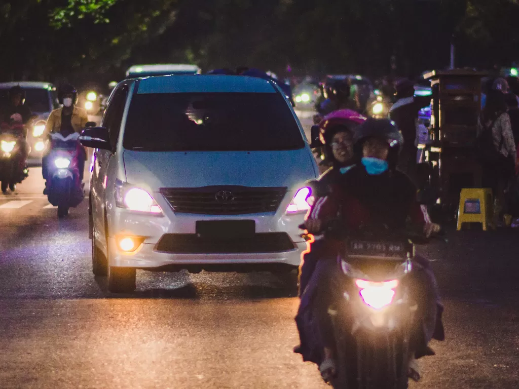 Mobil dan motor yang sedang melaju di jalanan pada malam hari (Ilustrasi/Unsplash/Ichsan Wicaksono)
