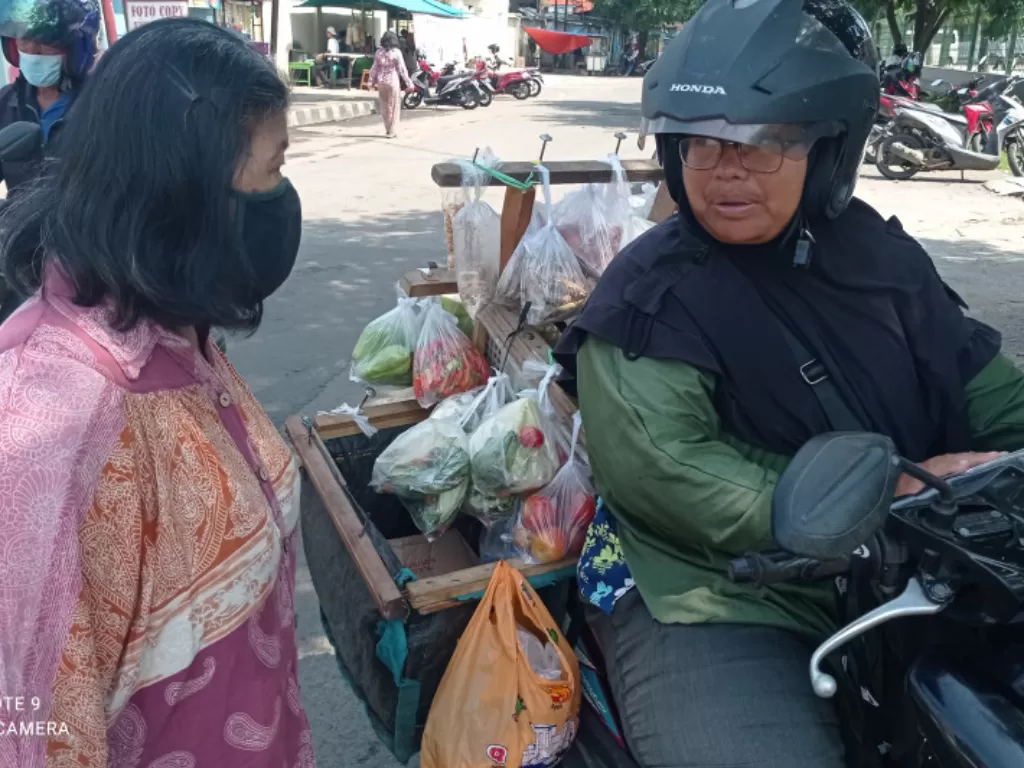 Seorang pedagang sayur keliling di Rangkasbitung saat melayani konsumen langganan. (ANTARA)