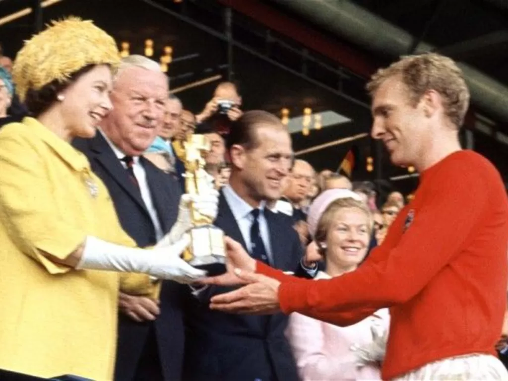 Ratu Elizabeth (kiri) menyerahkan trofi Piala Dunia kepada pemain Inggris Bobby Moore pada tahun 1966. (Istimewa)