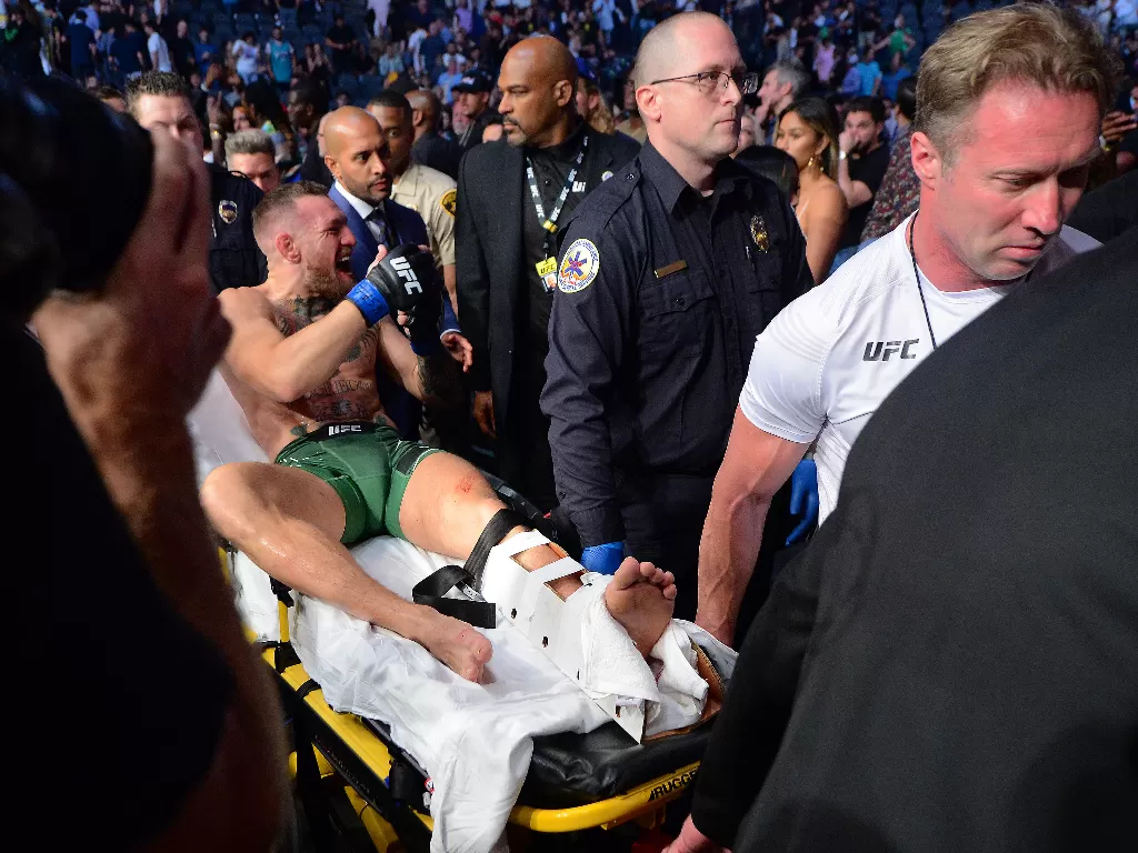 Conor McGregor saat ditandu karena ankle-nya patah (Mandatory Credit: Gary A. Vasquez-USA TODAY Sports)
