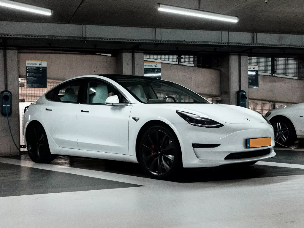 Tampilan mobil Tesla Model Y dengan warna putih (Ilustrasi/Unsplash/Jannis Lucas)
