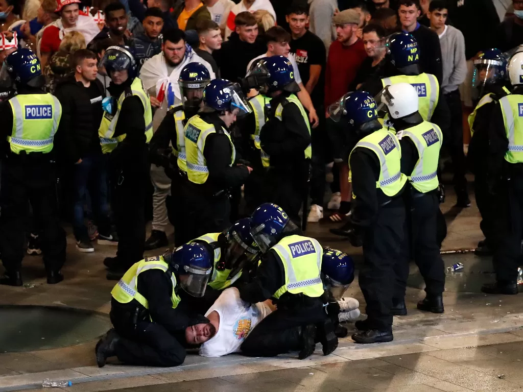 Polisi London menangkap suporter yang ricuh. (photo/Reuters/Peter Cziborra)