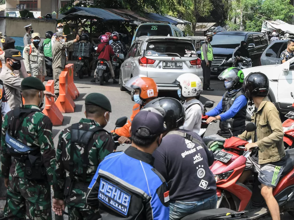 Petugas gabungan dari TNI, Polri, Dishub, dan Satpol PP memutarbalikkan kendaraan yang akan melintas di pos PPKM Darurat, Bekasi, Jawa Barat, Sabtu (3/7/2021). (ANTARA FOTO/ Fakhri Hermansyah).