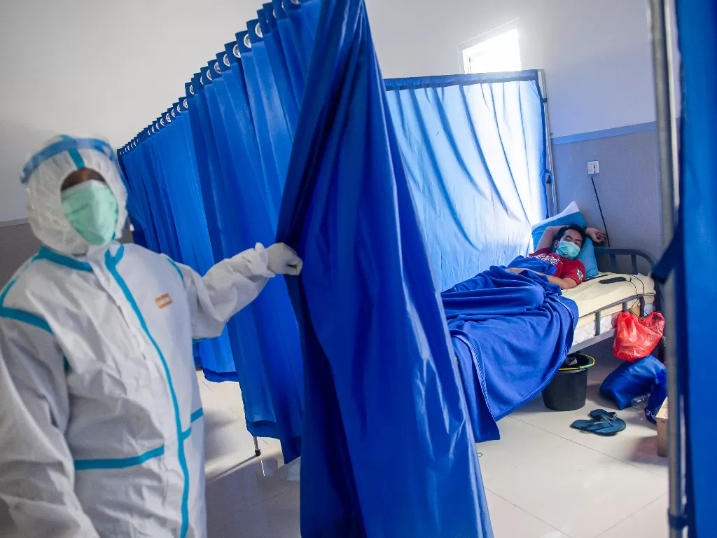 Seorang pasien yang terkonfirmasi positif Covid-19 dengan gejala ringan tidur di ruang isolasi di Rumah Sakit Darurat Pangkalan Marinir Jakarta, Sabtu (10/7/2021). (ANTARA FOTO/M Risyal Hidayat).