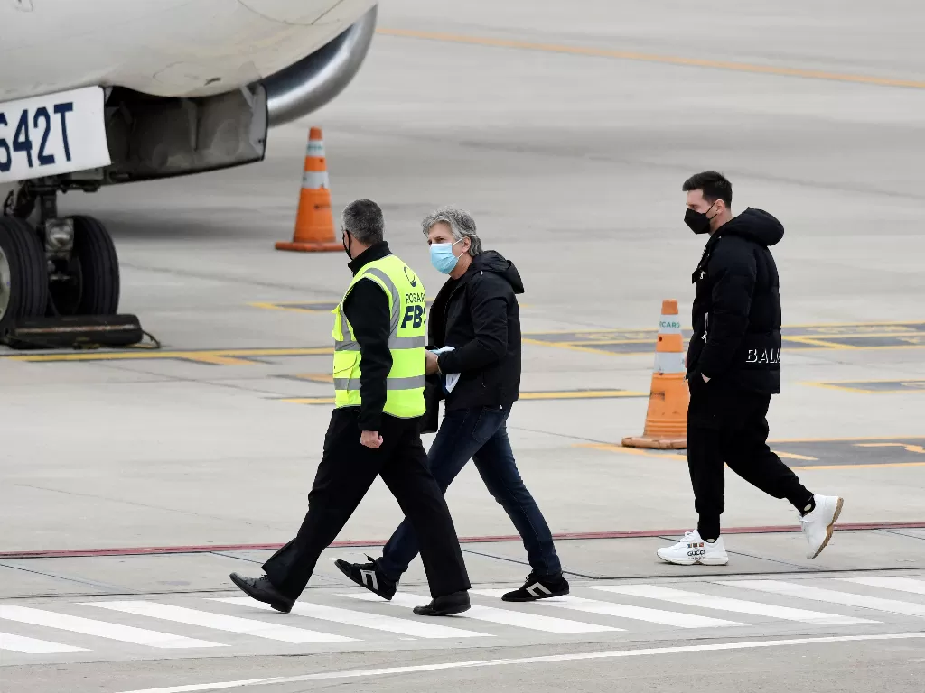 Lionel Messi (kanan) berjalan di landasan bersama ayahnya Jorge Messi sebelum naik pesawat di Bandara Internasional Islas Malvinas di Rosario, Argentina. (photo/REUTERS/STRINGER)