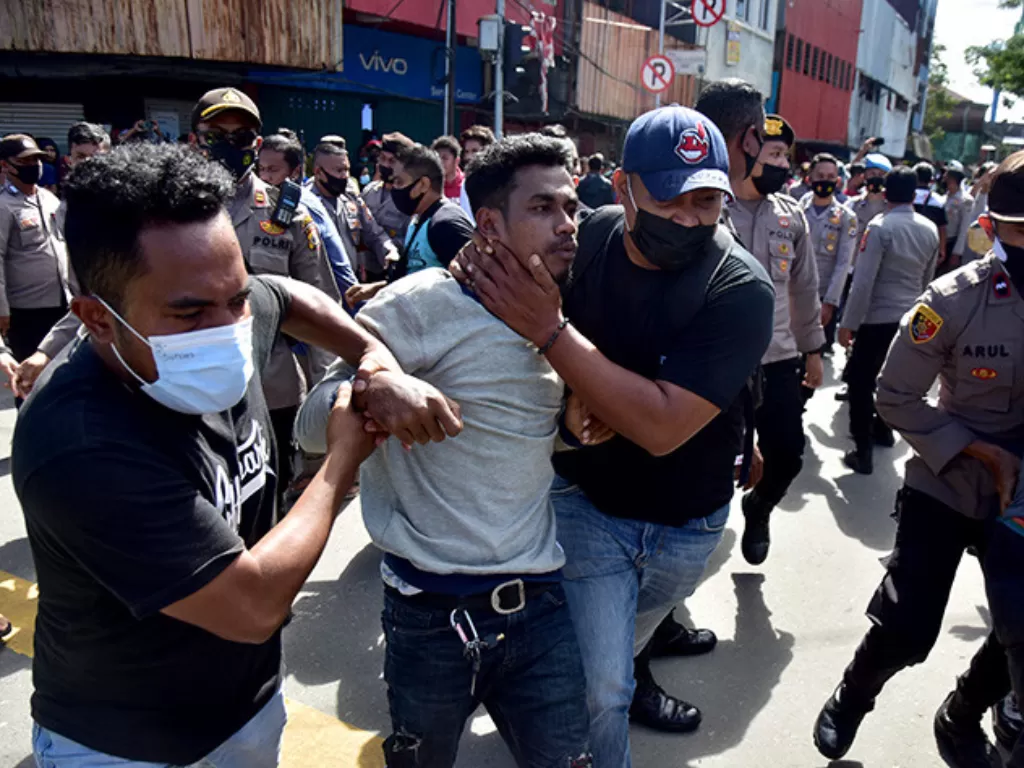 Sejumlah petugas polisi berpakaian preman mengamankan seorang demonstran yang diduga provokator saat membubarkan unjuk rasa di Kota Ambon, Provinsi Maluku, Jumat (16/7/2021). (ANTARA FOTO/FB Anggoro)