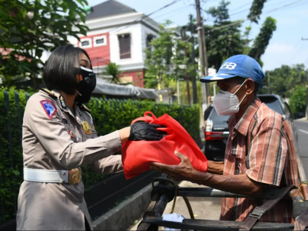  Polwan Korlantas Polri menyalurkan bantuan paket beras untuk para pemulung dan buruh cuci di kawasan Bintaro, Tangerang Selartan, Banten.  (ANTARA/HO-Humas Korlantas Polri) 