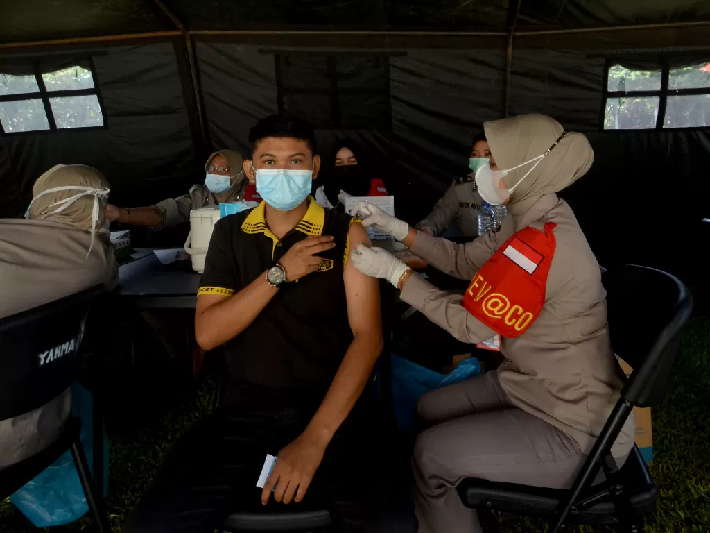 Warga mengikuti vaksinasi COVID-19 yang digelar Polda Sumbar dan Korem 032/Wirabraja di lapangan Imam Bonjol, Padang, Sumatera Barat, Minggu (20/6/2021). (ANTARA/Iggoy El Fitra)