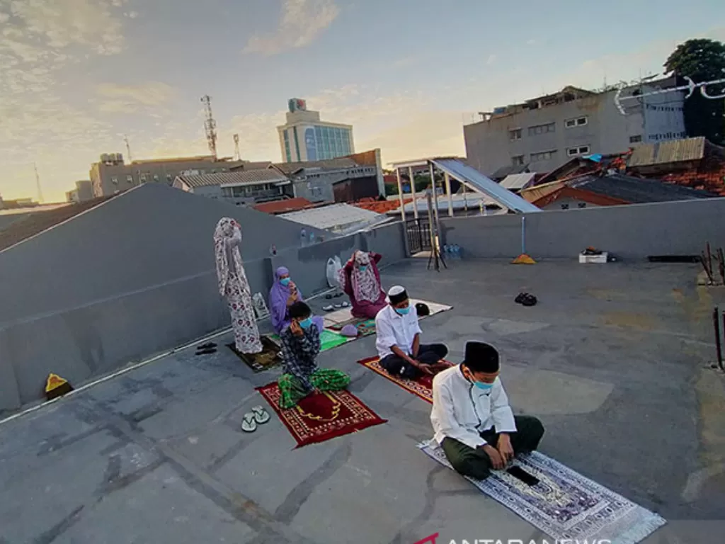Sejumlah perantau yang tinggal di Gang Kelinci, Pasar Baru, Jakarta Pusat, melaksanakan Shalat Ied di teras atap rumah (roof top). (ANTARA/M Risyal Hidayat)