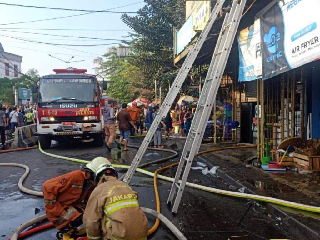 Petugas Sudin Gulkarmat Jakarta Timur memadamkan api yang membakar tujuh ruko di Duren Sawit, Jakarta, Selasa (20/7/2021). (ANTARA/HO-Sudin Gulkarmat Jakarta Timur)