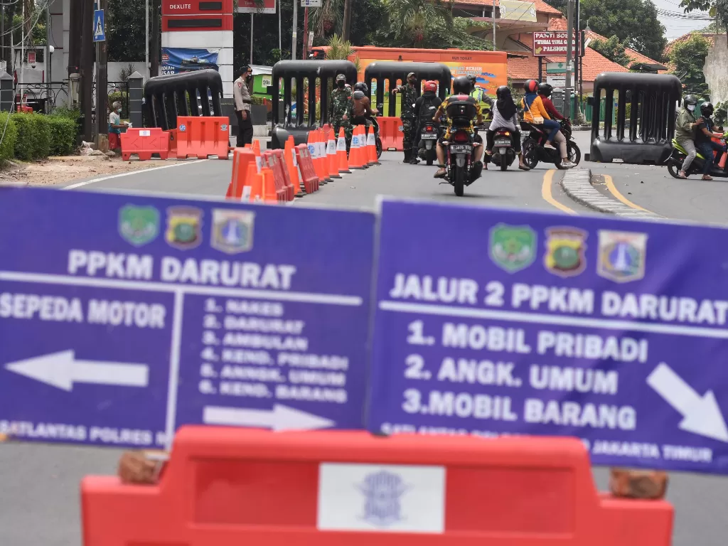 Warga mengendarai motor melintasi di Pos Penyekatan Mobilitas Masyarakat pada PPKM Darurat di Jalan Raya Bogor, Jakarta. (ANTARA FOTO/Indrianto Eko Suwarso).