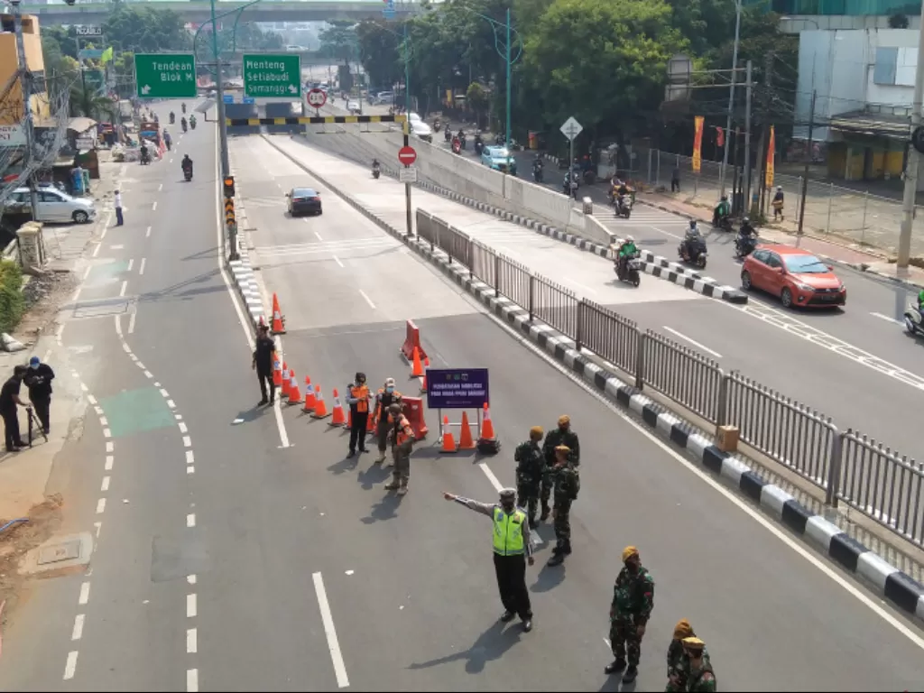 Petugas gabungan melakukan penyekatan lalu lintas di jalan lintas bawah Mampang Prapatan, Jakarta Selatan untuk menekan mobilitas penduduk, Kamis (15/7/2021). (ANTARA/Dewa Ketut Sudiarta Wiguna) 