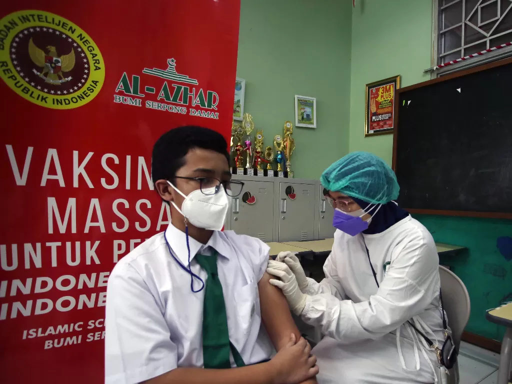 Petugas kesehatan dari Badan Intelijen Negara (BIN) menyuntikkan vaksin COVID-19 kepada seorang pelajar di Sekolah Al Azhar BSD, Tangerang Selatan, Banten, Senin (19/7/2021). Vaksinasi yang diselenggarakan oleh BIN dan Pemkot Tangerang Selatan ini merupak