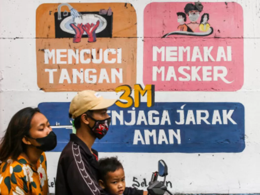 Pengendara melintas di dekat mural bertemakan Covid-19 di Petamburan, Jakarta, Rabu (21/7/2021). (ANTARA FOTO/Rivan Awal Lingga)