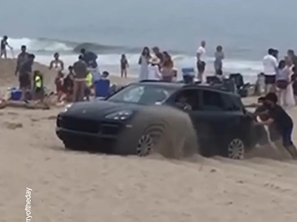 Mobil Porsche Cayenne yang terjebak di pasir pantai (photo/Facebook/Beach Day)